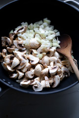 сooking onions and mushrooms on wok pan