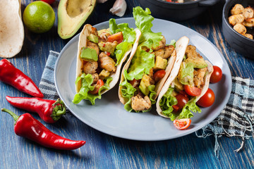 Authentic mexican tacos with chicken and salsa with avocado, tomatoes and chillies