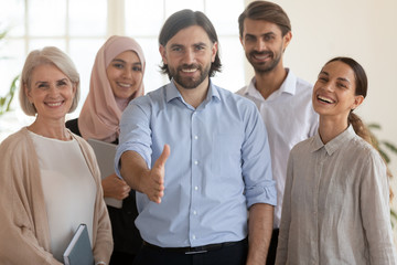 Happy ceo extend hand at camera stand with multicultural businesspeople