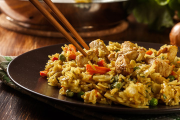 Fried rice nasi goreng with chicken and vegetables on a plate - 297065546