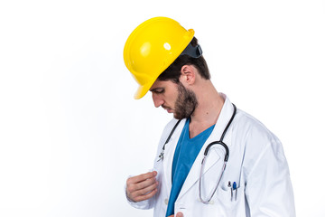 Medico sicuro con camice bianco e caschetto da operaio giallo