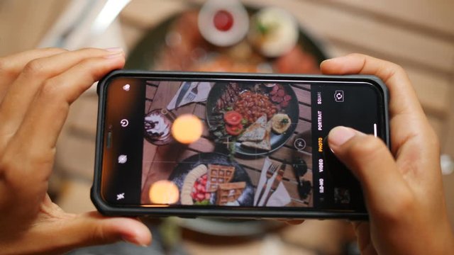 Female Taking Photo of Healthy Breakfast Using Mobile Phone in Vegan Restaurant. 4K Slowmotion Flatlay Food Photography on Wooden Table in American Diner. Thailand.