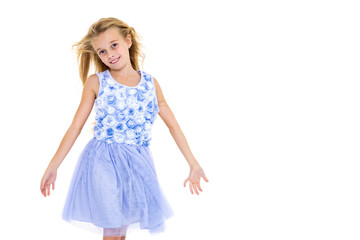 Naklejka premium Little girl in a dress developing in the wind.