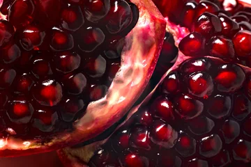 Gordijnen Delicious beautiful pomegranate on dark background. Close-up image of a red pomegranate © Maryana
