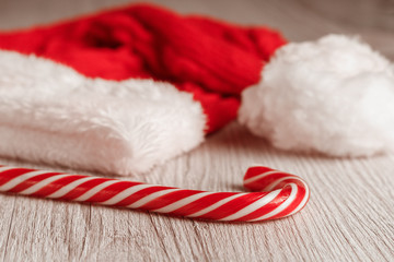 Christmas hat and Lollipop cane on wooden surface