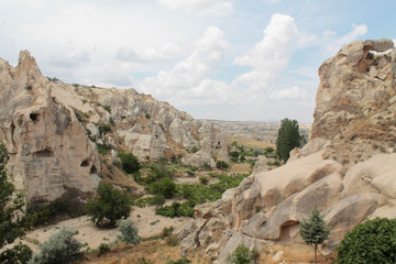 Fototapeta premium Splendid view of rocky hills surrounded by green trees in famous travel destination - Cappadocia, Turkey