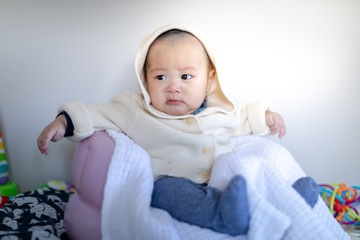 Adorable baby boy sitting in chair and waiting mother