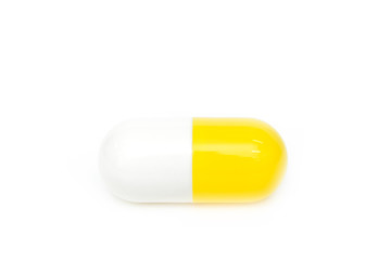 Close up of a big yellow capsule medicine on the white background. The concept of pharmaceutical treatment