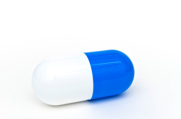Close up of a big blue capsule medicine on the white background. The concept of pharmaceutical treatment