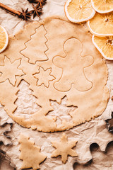 Christmas and New Year celebration traditions. Family home bakery, cooking traditional festive sweets. Gingerbread dough with christmas theme shapes and raw cookies