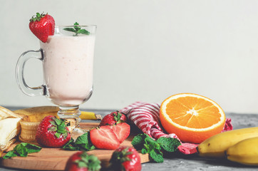 banana, strawberry and orange smoothies with mint on the table, front view