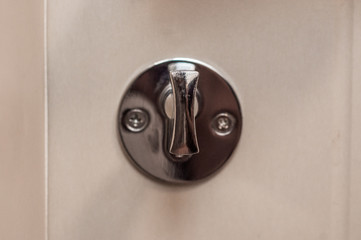 The door lock of white doors made of wood.