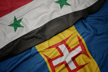 waving colorful flag of madeira and national flag of syria.