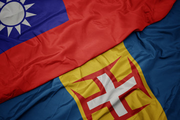 waving colorful flag of madeira and national flag of taiwan.
