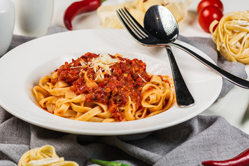 Pasta Fettuccine with spicy sauce in a white plate. Tomato sauce, parmesan, pepper and garlic