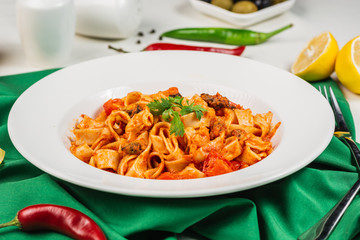 Tagliatelle pasta with seafood. Close up, Decorated with lemon, basil, shrimps, mussels, cheese, pepper