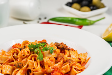 Tagliatelle pasta with seafood. Close up, Decorated with lemon, basil, shrimps, mussels, cheese, pepper