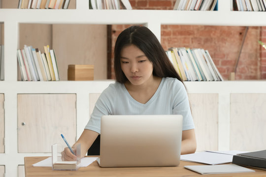 Asian student girl sitting at desk studying preparing for exams