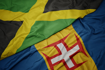 waving colorful flag of madeira and national flag of jamaica.