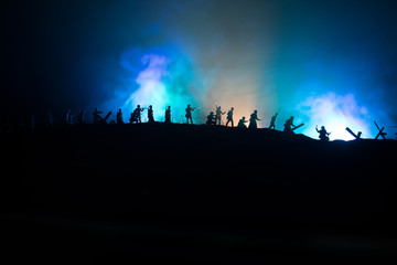 Fototapeta premium War Concept. Military silhouettes fighting scene on war fog sky background, World War German Tanks Silhouettes Below Cloudy Skyline At night. Attack scene. Armored vehicles and infantry.