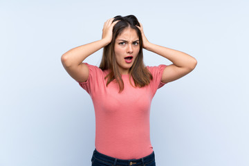 Young brunette girl over isolated blue background with surprise facial expression