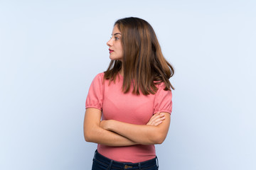 Young brunette girl over isolated blue background looking side