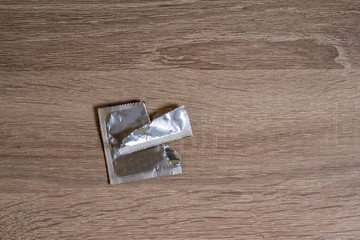 open condom packaging lies on a bedside table