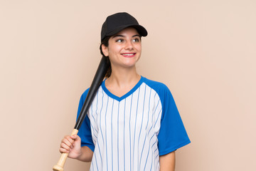 Young girl playing baseball over isolated background looking up while smiling