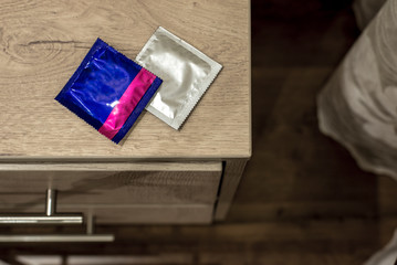 unused condoms lie on the bedside table