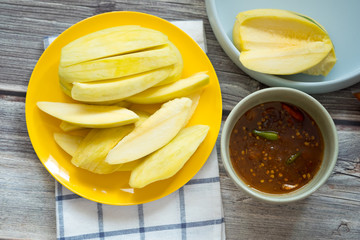 Slice of raw yellow mango with sweet fish sauce