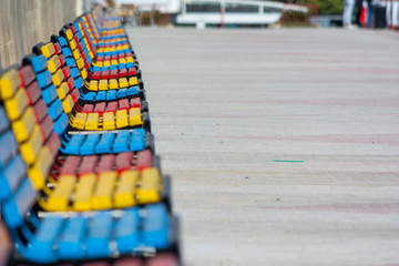 Obraz premium A lot of colorful benches in line on a sunny day