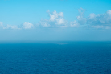 Naklejka na ściany i meble sailing boat far away on ocaen horizon, seascape aerial