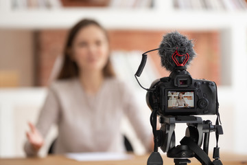 Woman seated in front of camera filming educational video