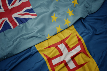waving colorful flag of madeira and national flag of Tuvalu .