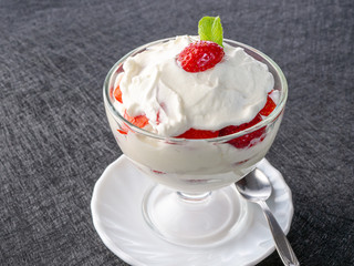 Strawberries with whipped cream in a glass bowl