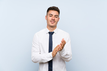 Handsome businessman over isolated blue background applauding