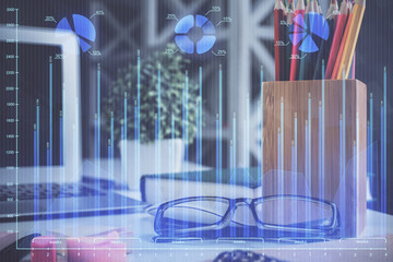 Financial chart hologram with glasses on the table background. Concept of business. Double exposure.
