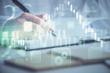 Multi exposure of woman's hands making notes with forex graph hologram. Concept stock market...