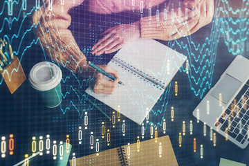 Forex graph on hand taking notes background. Concept of research. Double exposure