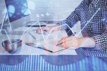 Double exposure of stock market chart with man working on computer on background. Concept of financial analysis.