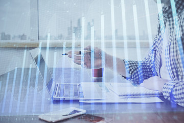 Obraz premium Double exposure of stock market chart with man working on computer on background. Concept of financial analysis.