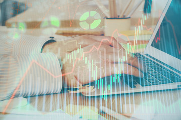 Multi exposure of stock market graph with man working on laptop on background. Concept of financial analysis.