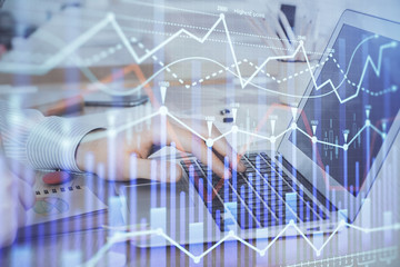 Multi exposure of stock market graph with man working on laptop on background. Concept of financial analysis.