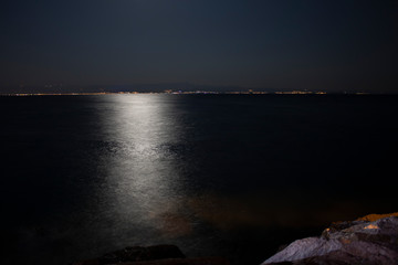 Moonlight shoots the sea. Taken with long exposure. Kayaks under the photograph.