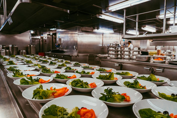 Many plates with salad. Preparation for lunch service on a cruise ship.