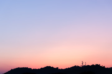 Silhouette of the telecommunications tower on the mountain with colorful sky.