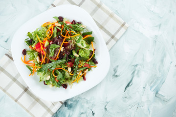 Portion of fresh and healthy salad in white plate on a gray background. Balanced food
