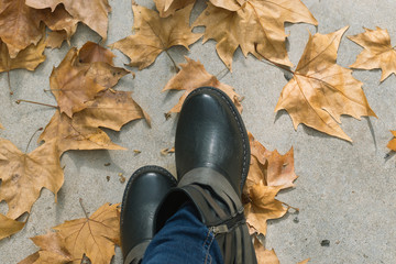 Feet stepping on dry autumn leaves