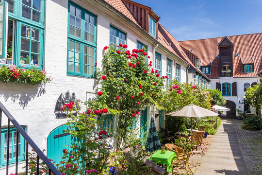 Colorful flowers at the facade of a white house in Flensburg, Germany
