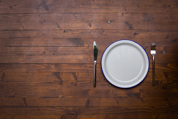 Empty white plate with a fork and a knife